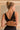 Jeune femme blonde de dos porte une brassière noire en tulle recyclé et coton biologique.