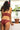 Femme de dos face à la fenêtre porte un ensemble de lingerie couleur grenat imaginé à Paris par Olly et confectionné en Hongrie.