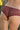 Femme de dos portant un shorty rouge foncé avec un motif de dentelle géométrique.