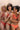 Trois femmes en lingerie terracotta se tiennent par les épaules et sourient à la caméra.