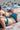 Deux jeunes femmes en bikini émeraude et terracotta sont allongées sur la plage.