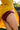 Femme en mouvement qui porte sous sa robe jaune, une jolie culotte rouge grenat en dentelle recyclée et coton biologique.