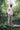 A black man is standing on a log in nature, with one hand in his pocket. He wears Saywood's Eddy Mens Patchwork Shirt colourblocked in orange and pale yellow, with long sleeves. Worn with taupe chinos and sunglasses.