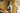 Woman in a green Mohair pointelle knit vest standing in a room with yellow brick walls and a window.