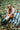 Woman sitting on a plaid blanket in a Mohair pointelle knit vest in a forest with fallen leaves