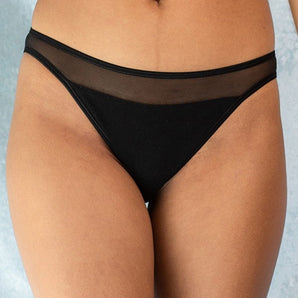 Jeune femme qui porte une culotte noire de la marque Olly lingerie, sexy et confortable. 