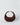 A HYER GOODS Piccola Ring Bag dark brown suede crescent-shaped shoulder bag with a gold-tone chain detail at the top of the strap, set against a plain light gray background. #color_chocolate-suede