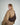 back view of a woman glancing over her shoulder at the camera, wearing an oversized khaki trench and a brown suede crossbody crescent bag across her back. #color_chocolate-suede