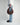 a profile of a person, cropped from the waist down, wearing a loose white button down shirt, light jeans, brown loafers and holding a bordeaux hyer goods ring bag in their fingertips #color_bordeaux-vintage