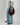 a cropped photo of a womans light blue jeans, brown pointy leather boots and chocolate suede crescent bag hanging from her fingertips #color_chocolate-suede