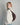 profile shot of a woman in an oversized cream sweater, light blue jeans, and a slouchy dark brown suede shoulder bag with gold hardware #color_chocolate-suede