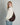 profile shot of a woman in an oversized cream sweater, light blue jeans, and a slouchy dark brown suede crossbody crescent bag with gold hardware #color_chocolate-suede