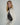 profile shot of a woman wearing a cream oversized turtlneck sweater and a brown leather crescent shoulder bag #color_chocolate