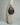 a cropped shot of a woman's light khaki pants and brown pointy boots, she holds a brown leather crescent bag in her hand #color_chocolate