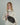 a woman wears an oversized cream turtleneck sweater with a dark brown leather crossbody crescent bag slung on top. #color_chocolate