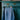 The Japanese denim Amelia Wide Leg Culotte Trousers are hanging on a rose gold hanger from the ornate gold handle of a turquoise vintage wooden cupboard, with metal cabinet on top. The back of the trousers can be seen, with the signature Saywood embroidered flower on the back pocket, and triangle cut out at the waist. The trousers have been worn so the denim has slightly washed down with age.