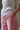 A woman stands sideways to the camera, showing a close up of her mid body. She is wearing Saywood's Joni Puff Sleeve Blouse in lemon. The scallop hem detail and fit and flare darts can be seen clearly. Worn with the Amelia Wide Leg Trousers in pink cotton corduroy. she has her hands in her trouser pockets.